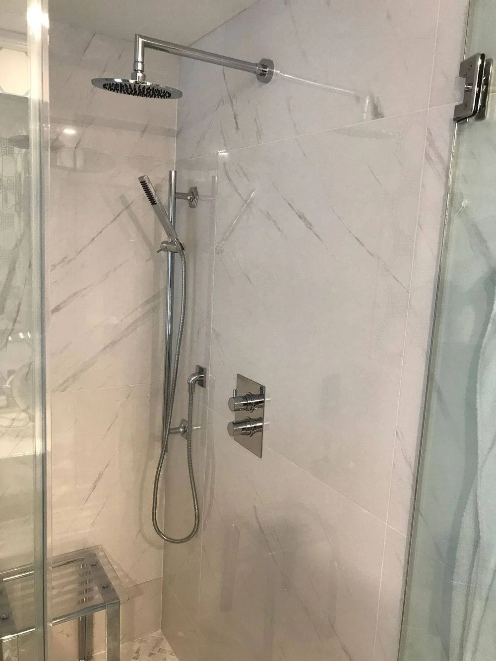 Luxury shower installation with dual shower heads and marble tile in Westchester County NY